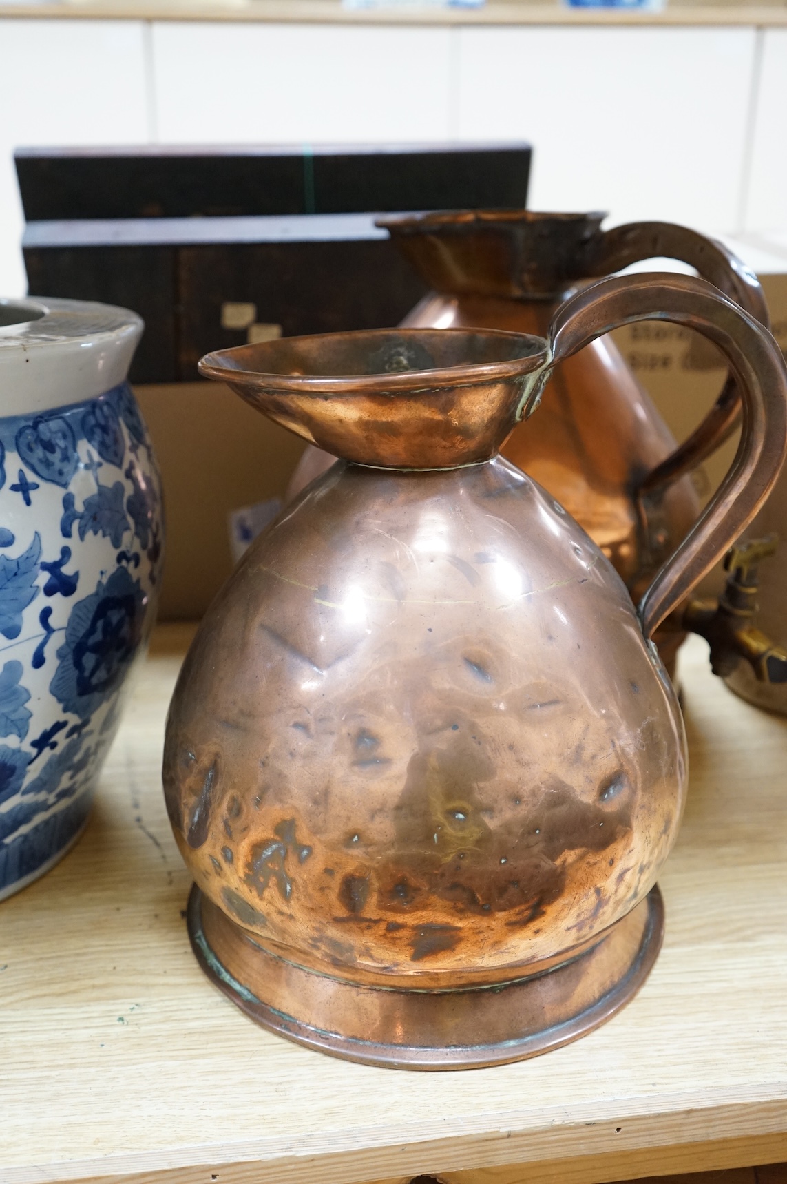 Three graduated copper haystack measures, H 39cm x W 40cm (inc spout), H 35cm x 25cm and H25cm x 18cm, Three stoneware jars H 32cm x W 20cm (two jars), H 20cm x W 16cm (1 jar)